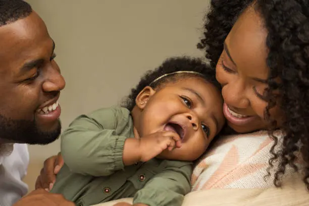 African American Family playing and laughing with their daughter.African American Family playing and laughing with their daughter.